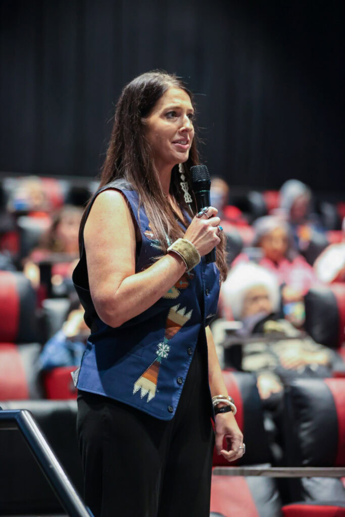 A woman holds a microphone.