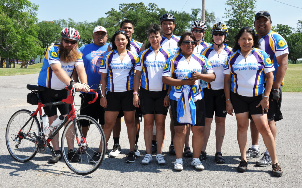 A group of people in cycling gear pose for a photo