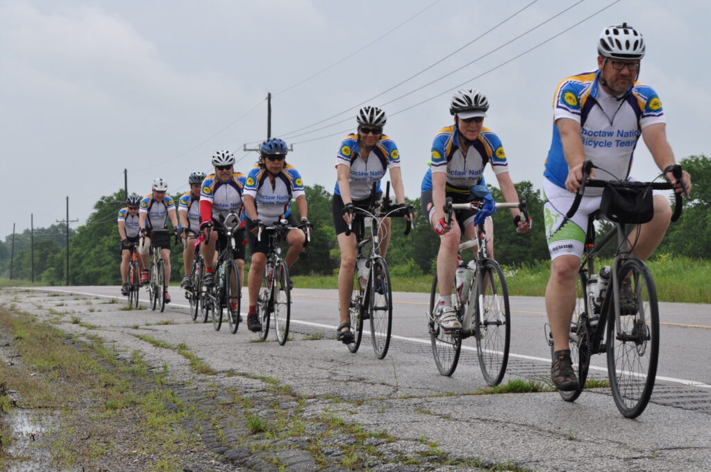 A group of cyclists ride down the road.