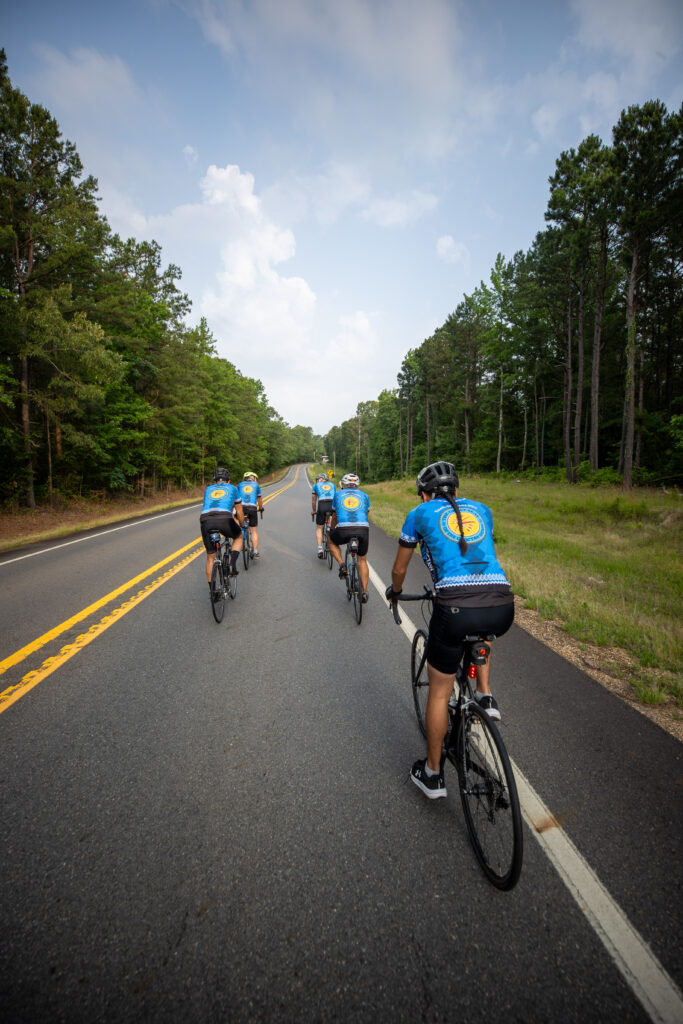 A group of cyclists ride down the road.