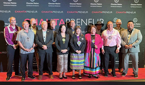 Choctaw leaders pose for a photo in front of the Chahtapreneur backdrop.