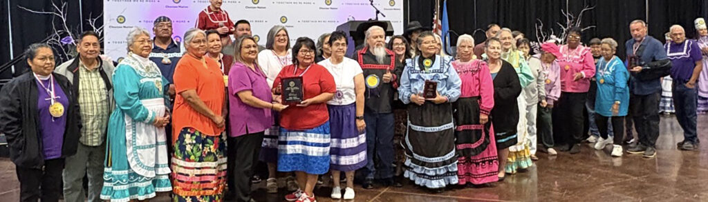 A large group of choctaw elders dressed in traditional clothing.