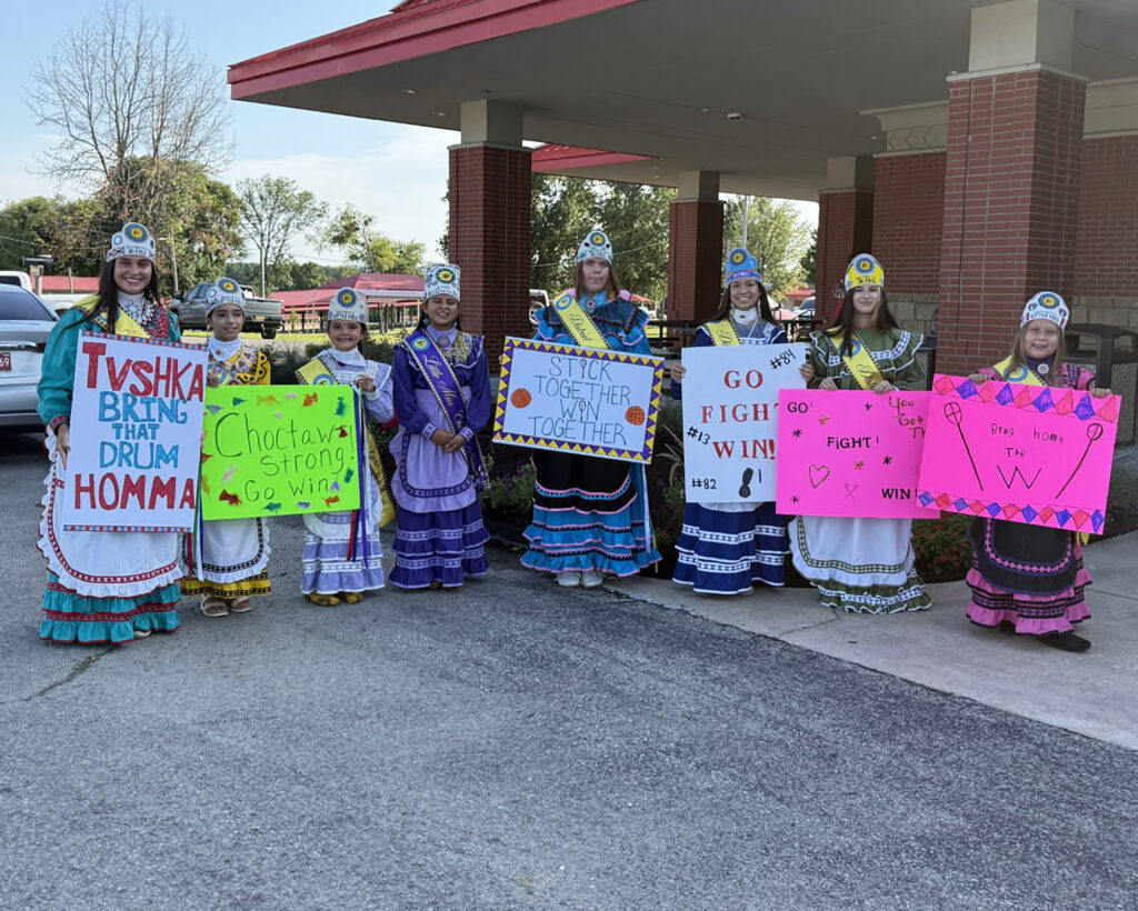 Choctaw princesses hold up signs.