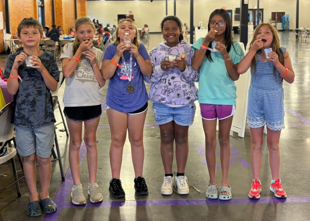 A group of campers enjoys cups of ice cream.