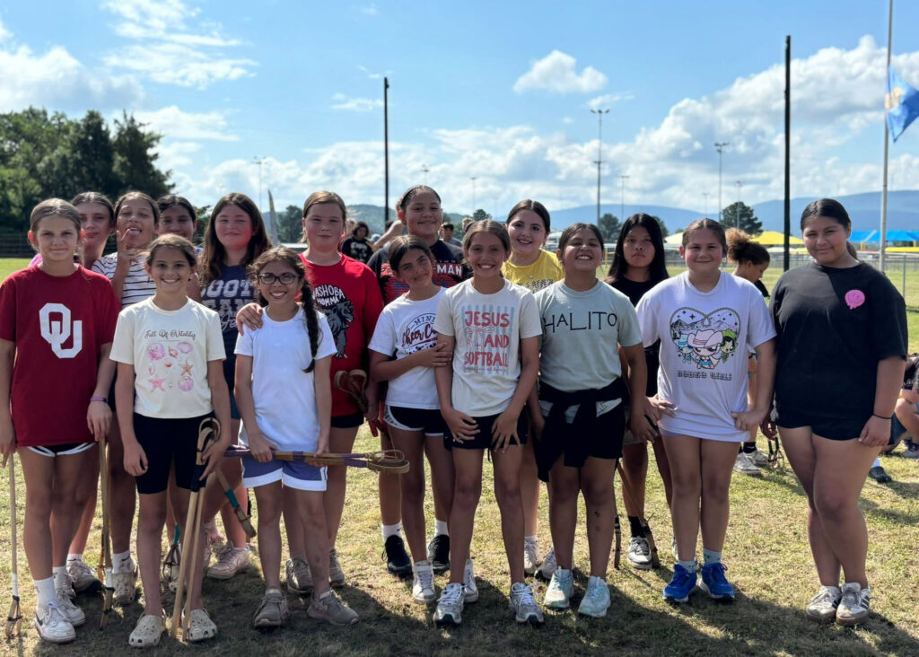 A group of campers poses for a photo on the stickball field.