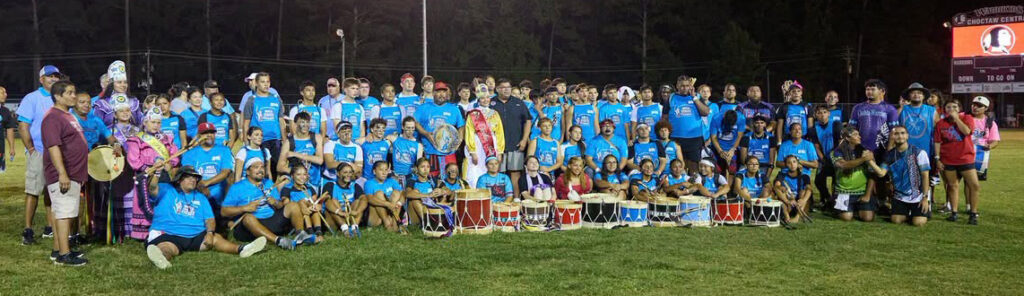 Youth stickball team pose for photo on field.