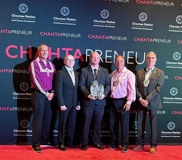 Tribal leadership p[ose for a photo with an award winner.