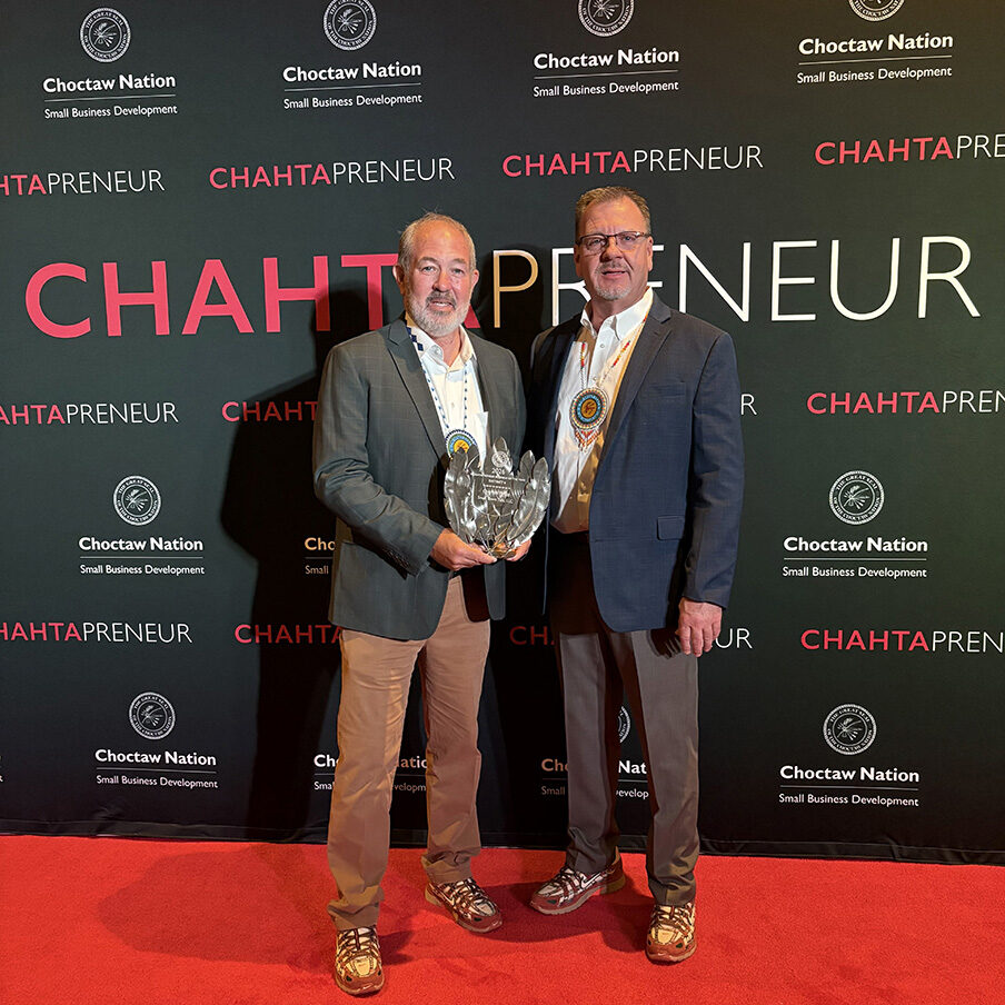 Two men pose for a photo at an awards banquet.
