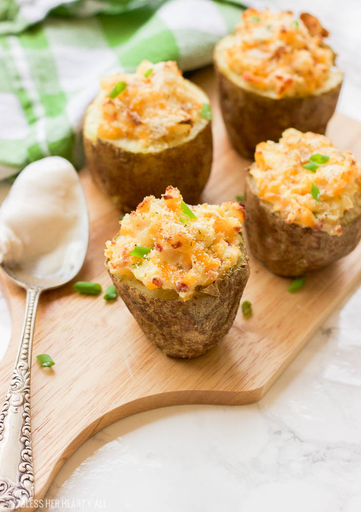 These gluten-free greek yogurt twice baked potatoes are perfectly portioned baked potatoes that are then loaded with healthy creamy greek yogurt, bacon crumbles, spices, and cheese and then baked a second time until the tops are golden brown and crunchy.