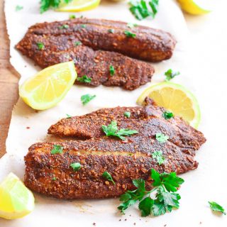 blackened flounder on paper with lemon slices