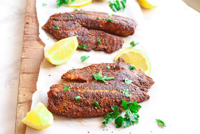 blackened flounder on paper with lemon slices