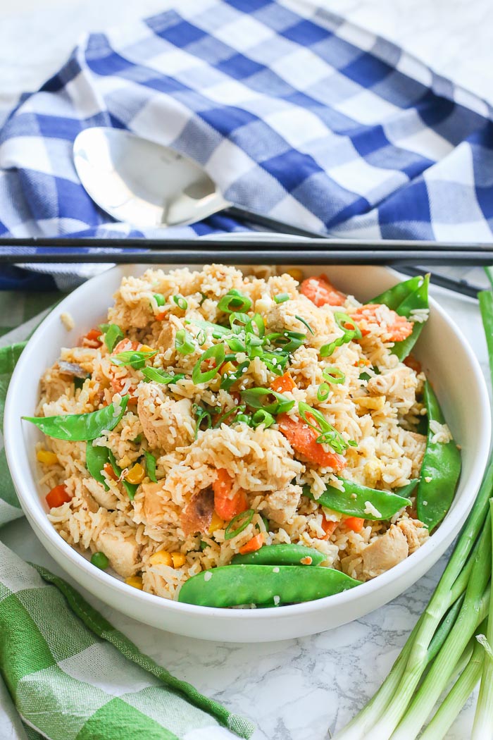 fried rice with chicken and peas in white bowl