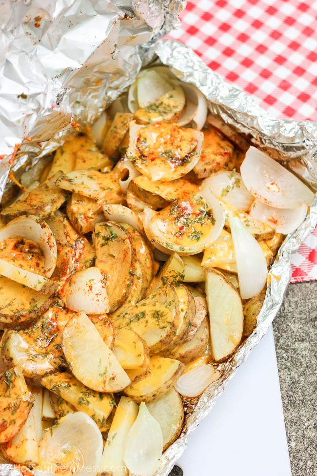 Ooey gooey melty cheesy with no strings attached {as in no dirty dishes to clean!}. What else do I gotta say? {She drops her mic, brushes her hands off, turns around and walks away}. These simple and tasty potato slices are tossed in a layer of cheeses and sweet onion, sprinkled in paprika, parsley, and some “heat”, loaded onto some tin foil and kissed on the grill till tender, crispy on the outside, and melty everywhere else. If stringy melty cheese gets to your heart, you will fall in love with these easy sizzlin’ campfire taters.