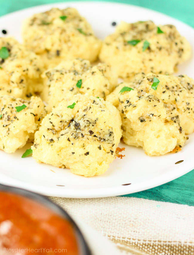 Soft gooey rolls that are topped with a fresh garlic butter sauce then sprinkled with parmesan and coarse sea salt and then smothered in garlic butter once again. These gluten-free bites are a quick and easy game-changer for any meal that they are served with! www.blessherheartyall.com