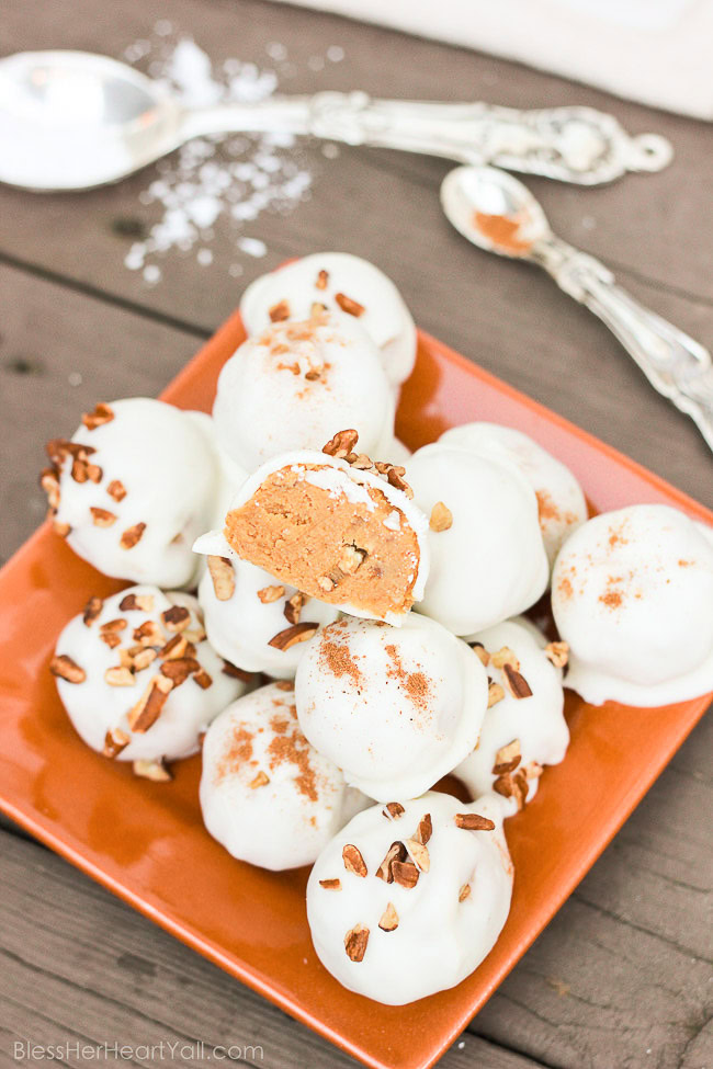 These pumpkin pecan truffles have smooth creamy pumpkin centers with pecan pieces hidden inside. The white chocolate coating is drizzled overtop and more pecan pieces sprinkled for the finale. Perfect no-bake party treats that can be quickly made! www.blessherheartyall.com