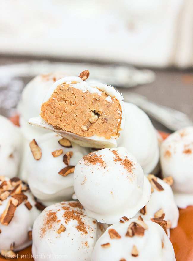 These pumpkin pecan truffles have smooth creamy pumpkin centers with pecan pieces hidden inside. The white chocolate coating is drizzled overtop and more pecan pieces sprinkled for the finale. Perfect no-bake party treats that can be quickly made! www.blessherheartyall.com