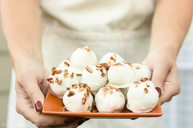 These pumpkin pecan truffles have smooth creamy pumpkin centers with pecan pieces hidden inside. The white chocolate coating is drizzled overtop and more pecan pieces sprinkled for the finale. Perfect no-bake party treats that can be quickly made! www.blessherheartyall.com