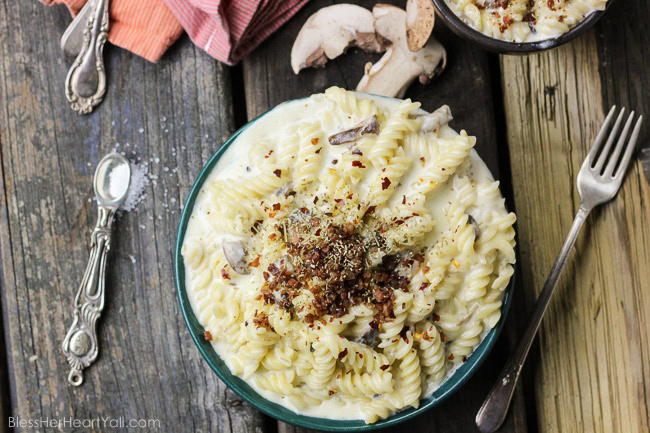 This spicy gluten-free mac and cheese recipe will blow your socks off in under 30 minutes! Let's combine bacon, mushrooms, truffle oil, some heat, and mac and cheese, shall we? Then we will create spicy, creamy, cheesy perfection. www.blessherheartyall.com