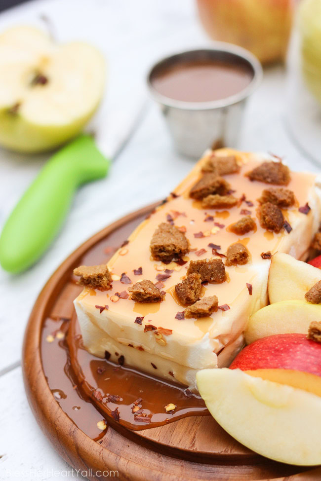 This Spicy Caramel Apple Dip is a 2-minute recipe that is both simple to make and easy to scarf down. Included in this recipe are healthier ingredients like greek yogurt and honey as well as a touch of spicy pepper, caramel drizzle, and gluten-free ginger snap crumbles, for a sweet and spicy, creamy and crunchy dip that's the perfect fall appetizer or treat for you and your hungry friends! www.blessherheartyall.com