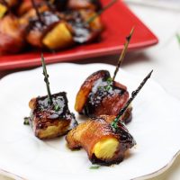 These bacon wrapped pineapple with sriracha lime glaze bites are an easy to-put-together appetizer for any party! Juicy pineapple is wrapped up in thick-cut applewood smoked bacon and then drizzled with a sriracha lime glaze before being baked in the oven to sweet and savory perfection! Yum! www.BlessHerHeartYall.com