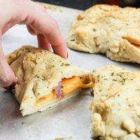 These gluten-free ham and cheese hot pockets are the real deal! Perfectly crispy pockets of smooth soft dough are stuffed with leftover Christmas ham and melty cheese, closed up, and brushed with an olive oil, honey, brown sugar, and garlic sauce. It's the perfect tasty meal on-the-go and a great way to finish off those Christmas ham leftovers! www.blessherheartyall.com