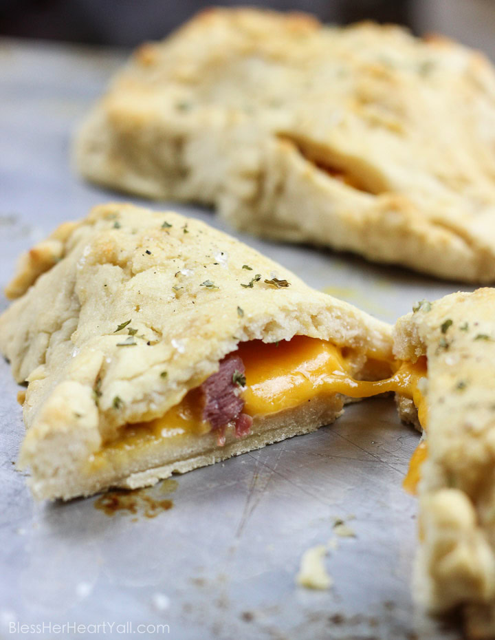 These gluten-free ham and cheese hot pockets are the real deal! Perfectly crispy pockets of smooth soft dough are stuffed with leftover Christmas ham and melty cheese, closed up, and brushed with an olive oil, honey, brown sugar, and garlic sauce. It's the perfect tasty meal on-the-go and a great way to finish off those Christmas ham leftovers! www.blessherheartyall.com