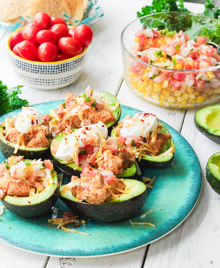 These chicken taco avocado boats are a quick and tasty option for your party or appetizer table. These are a healthy alternative to tacos while keeping that punch of flavor! www.BlessHerHeartYall.com