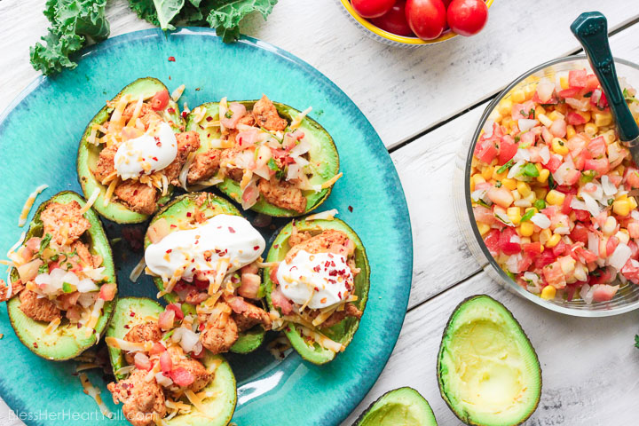 These chicken taco avocado boats are a quick and tasty option for your party or appetizer table. These are a healthy alternative to tacos while keeping that punch of flavor! www.BlessHerHeartYall.com