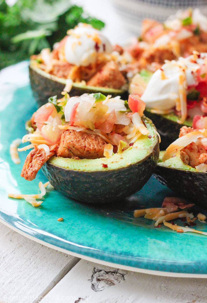 These chicken taco avocado boats are a quick and tasty option for your party or appetizer table. These are a healthy alternative to tacos while keeping that punch of flavor! www.BlessHerHeartYall.com