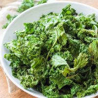 These easy Garlic Kale Chips are just as tasty as store bought chips, are just as inexpensive, and can be made in just minutes! www.BlessHerHeartYall.com