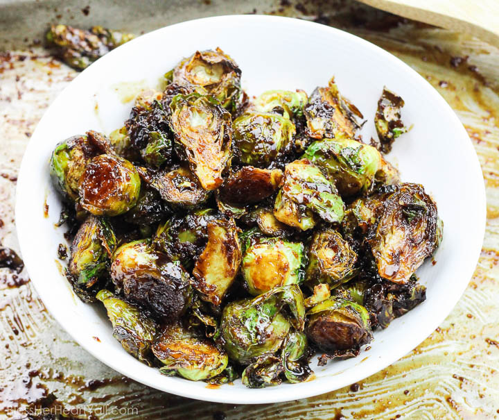 These roasted bacon walnut brussel sprouts are an easy side dish full of sweet hearty flavors! The sprouts are roasted in lemon juice and olive oil before being drizzled with a bacon walnut reduction and then quickly roasted again! www.BlessHerHeartYall.com