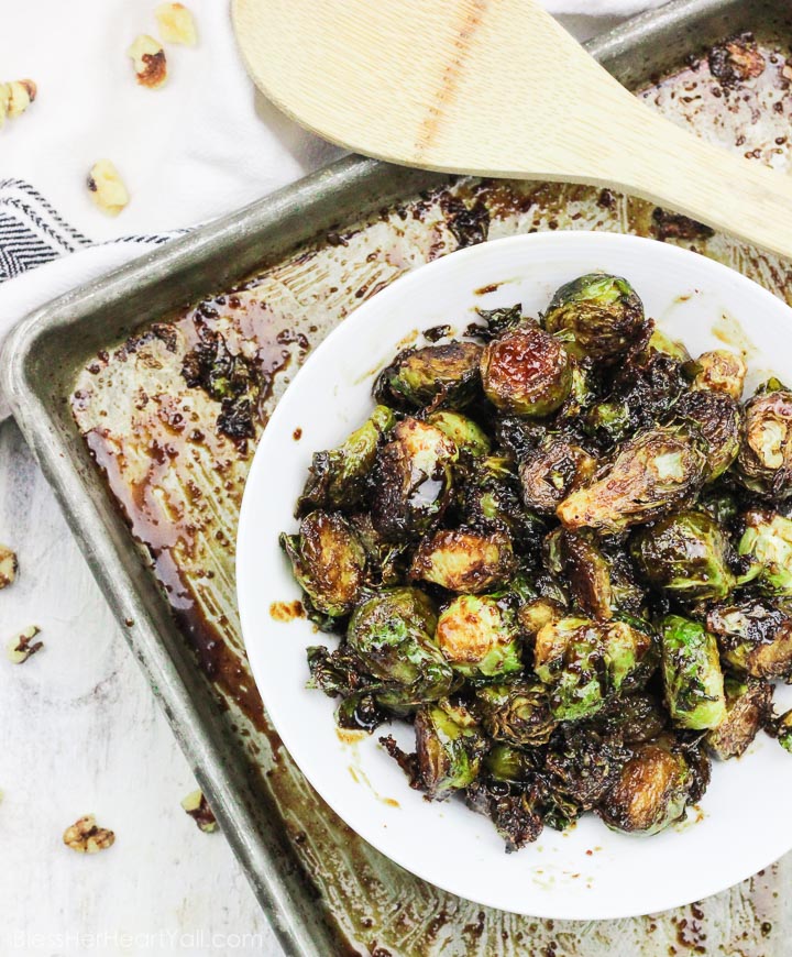 These roasted bacon walnut brussel sprouts are an easy side dish full of sweet hearty flavors! The sprouts are roasted in lemon juice and olive oil before being drizzled with a bacon walnut reduction and then quickly roasted again! www.BlessHerHeartYall.com