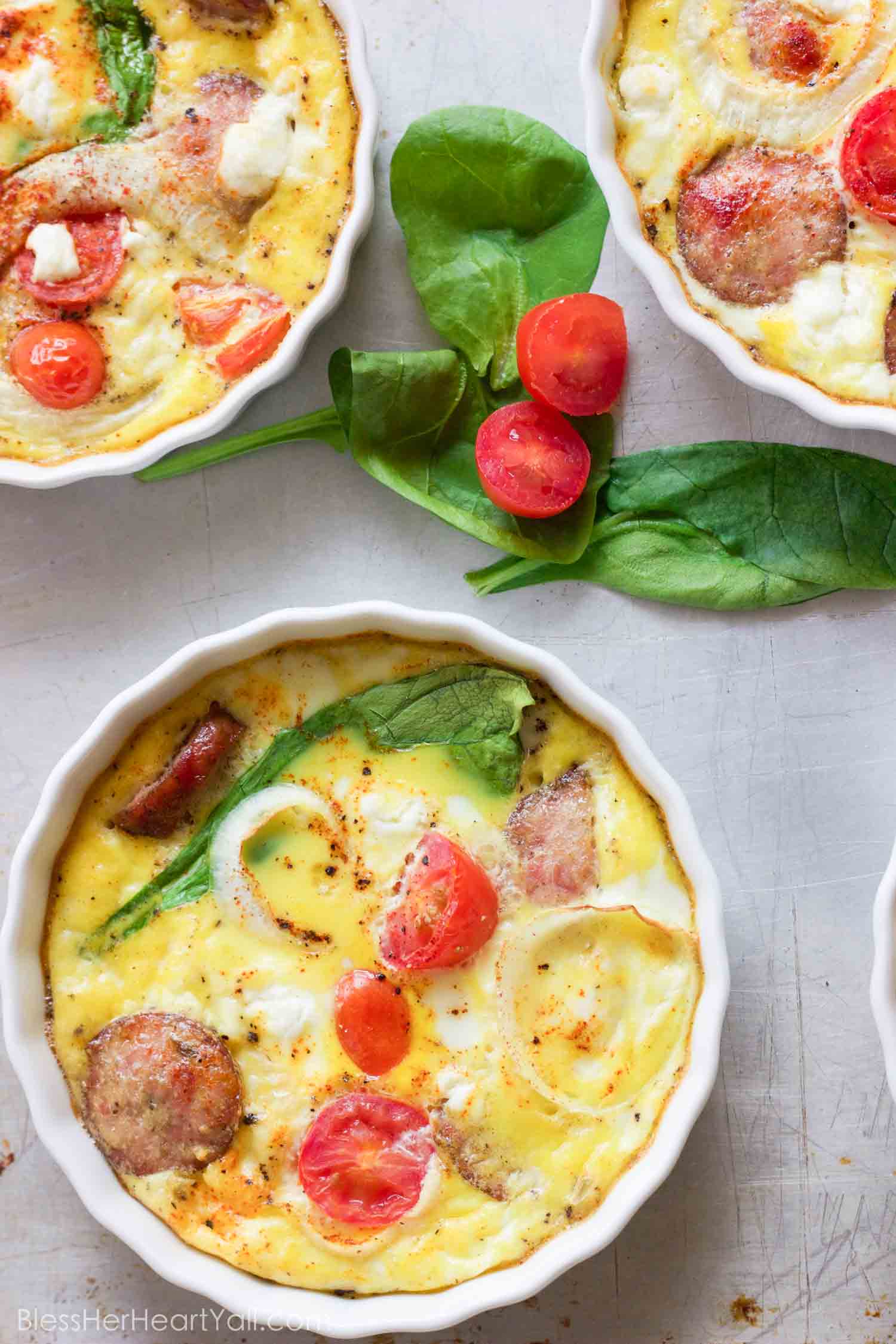 This gluten-free protein packed goat cheese egg bake combines the protein punch of fresh eggs, spinach, and breakfast sausage, with the flavors of creamy goat cheese, tomatoes and a little sweet onion slices for one amazing baked breakfast to fuel your morning right!