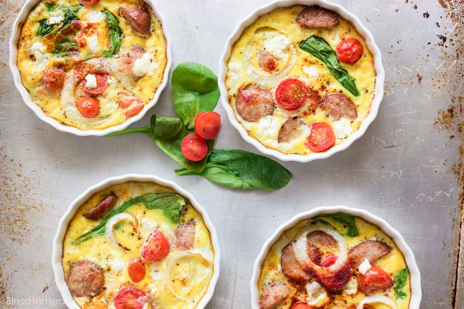 This gluten-free protein packed goat cheese egg bake combines the protein punch of fresh eggs, spinach, and breakfast sausage, with the flavors of creamy goat cheese, tomatoes and a little sweet onion slices for one amazing baked breakfast to fuel your morning right!