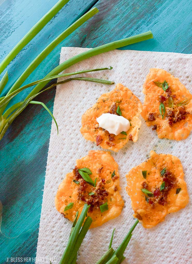 Loaded bacon cheddar crisps are the perfect 5 ingredient baked finger food for your next party! They combine cheddar, bacon, garlic, and green onion into a gluten-free and low carb snack that takes just minutes to make! Place a dollop of sour cream on them and you have a new easy low carb version of loaded potato skins!