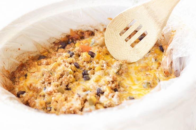 This slow cooker mexican quinoa dip is the perfect gluten-free, vegetarian, and paleo friendly tailgating comfort food! It's warm and gooey, filling and nutritious, and cooks itself in the slow cooker for a quick 2-3 hours. Use this recipe as a dip with your favorite sweet potato chips, rolled up in a tortilla for a quick enchilada, or toss it over a salad to add a burst of flavor!