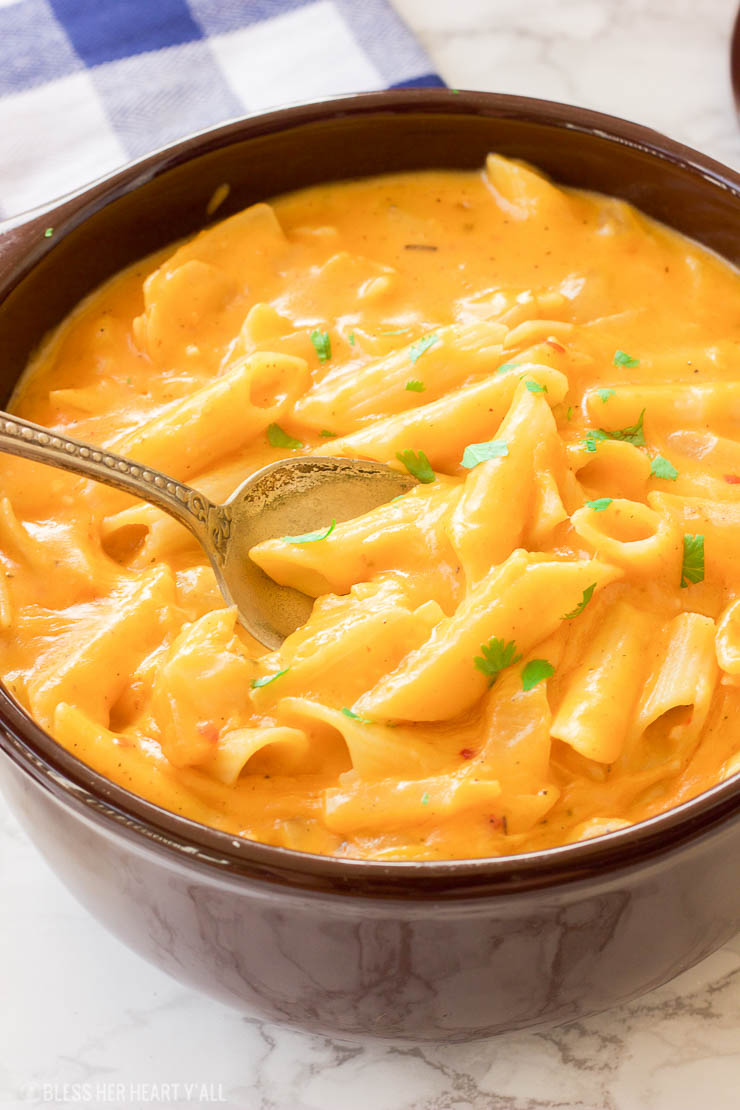 This gluten-free pumpkin mac and cheese recipe is the ultimate cheesy fall comfort food. Gluten-free noodles are cooked in a pumpkin, sage, and nutmeg sauce and just before serving are smothered in gooey cheddar and parmesan cheeses.