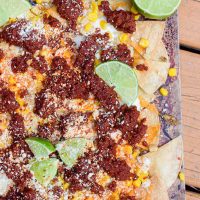 Put your big boy pants on for these spicy mexican street corn nachos with chorizo. These cheat-day nachos bring out all the cheesy, spicy, lime flavors of mexican street corn with the hearty addition of spicy chorizo meat. Perfect for this football-themed party all season long!