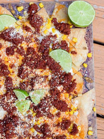 Put your big boy pants on for these spicy mexican street corn nachos with chorizo. These cheat-day nachos bring out all the cheesy, spicy, lime flavors of mexican street corn with the hearty addition of spicy chorizo meat. Perfect for this football-themed party all season long!