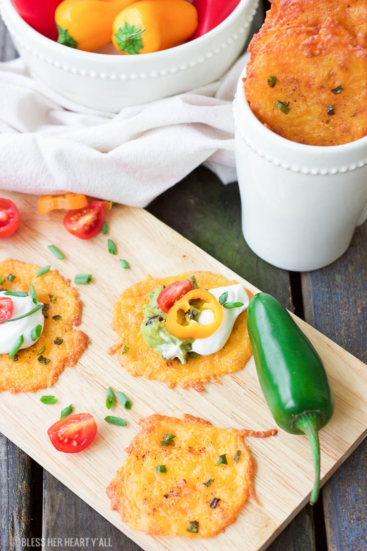 Taco cheese crisps are an easy and quick baked party recipe! These crispy cheese dippers are the perfect appetizer or snack for any gluten-free or low carb munchers and are huge hits at tailgating parties! All you need is cheddar cheese, taco seasoning, your favorite taco toppings, and a few minutes of oven time! Yes!