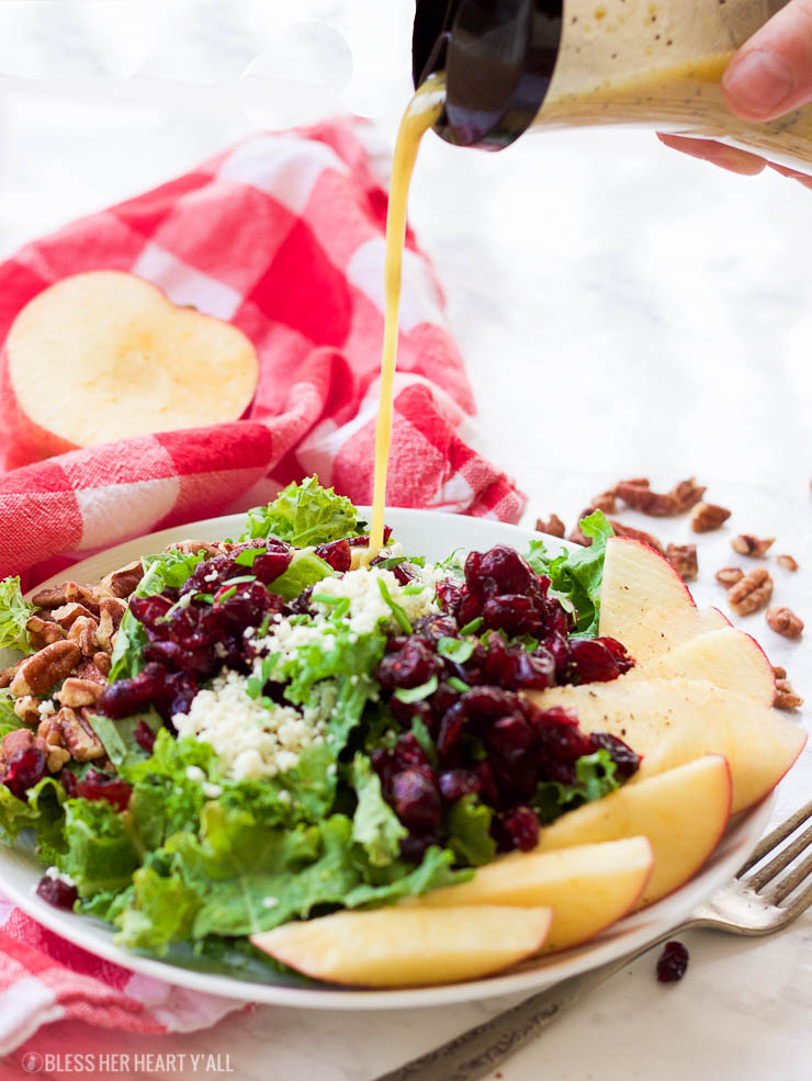 This apple cider poppyseed salad throws the season's best combination of juicy apples, crunchy pecans, sweet cranberries, and savory blue cheese crumbles over a bed of chopped kale and drizzles on a 2-minute apple cider poppyseed vinaigrette. It's big on nutrients and fall flavors and is gluten-free and paleo-friendly! www.blessherheartyall.com