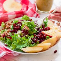 This apple cider poppyseed salad throws the season's best combination of juicy apples, crunchy pecans, sweet cranberries, and savory blue cheese crumbles over a bed of chopped kale and drizzles on a 2-minute apple cider poppyseed vinaigrette. It's big on nutrients and fall flavors and is gluten-free and paleo-friendly! www.blessherheartyall.com