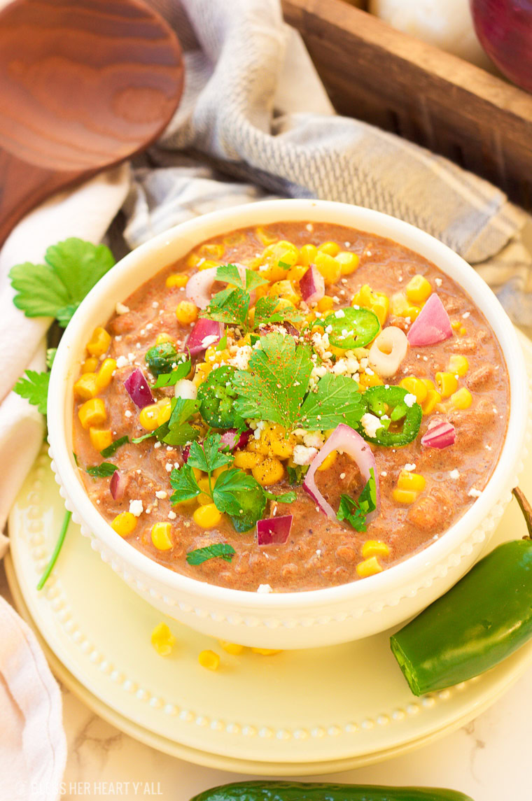 This slow cooker white turkey chili combines juicy leftover roasted turkey, chunky vegetables, and garlic, oregano, paprika, and spice to make a delicious stick-to-your-ribs meal that's so simple to make and so comforting to eat! It's also gluten free, dairy free and low carb! www.blessherheartyall.com