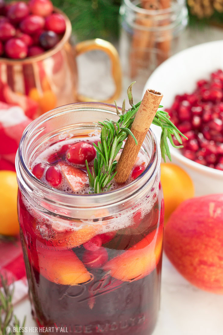 This winter pomegranate cranberry Christmas sangria recipe is a quick and easy twist on the popular sangria drink. Impress everyone at your next holiday or Christmas party with this sparkling red wine cocktail with apples, oranges, pomegranate, cranberry, rosemary, and cinnamon sticks! Get your drink on fancy pants!
