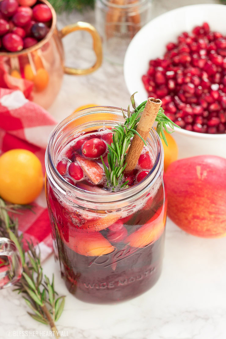 This winter pomegranate cranberry sangria recipe is a quick and easy twist on the popular sangria drink. Impress everyone at your next holiday or Christmas party with this sparkling red wine cocktail with apples, oranges, pomegranate, cranberry, rosemary, and cinnamon sticks! Get your drink on fancy pants!