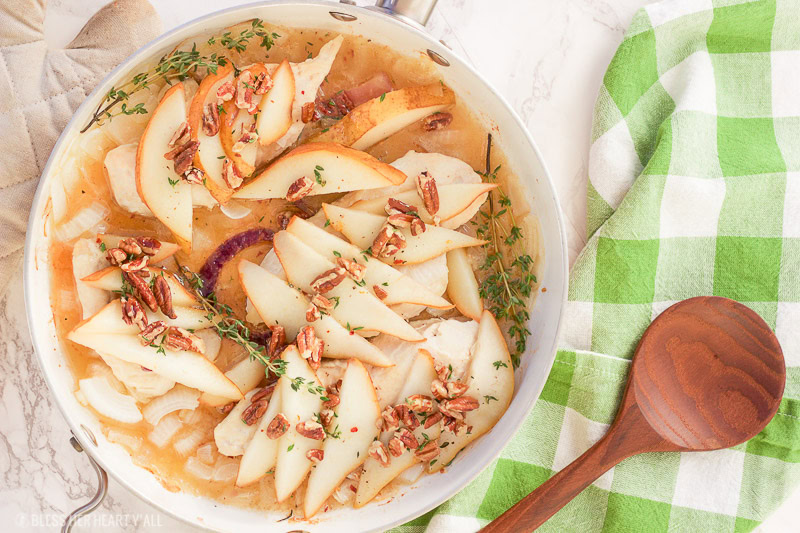 This pear pecan chicken skillet roasts juicy chicken breasts in a sweet and savory honey and thyme sauce, topped to perfection with roasted pears and chopped pecans. This is one easy weeknight recipe you can't pass up!