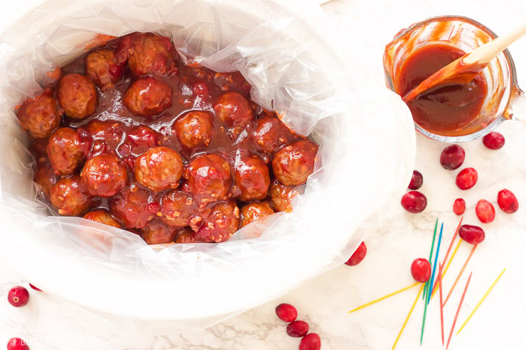 These spicy cranberry bacon bbq meatballs are the ultimate in sticky finger foods just in time for the holidays! A quick homemade cranberry sauce is melted and smothered into barbecue sauce and hot spices for the perfect sweet and spicy no-fuss pop-able party bites!