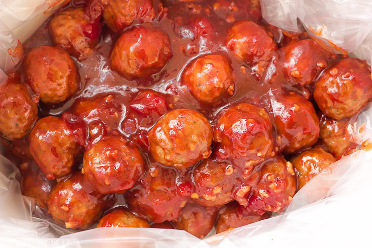 These spicy cranberry bacon bbq meatballs are the ultimate in sticky finger foods just in time for the holidays! A quick homemade cranberry sauce is melted and smothered into barbecue sauce and hot spices for the perfect sweet and spicy no-fuss pop-able party bites!