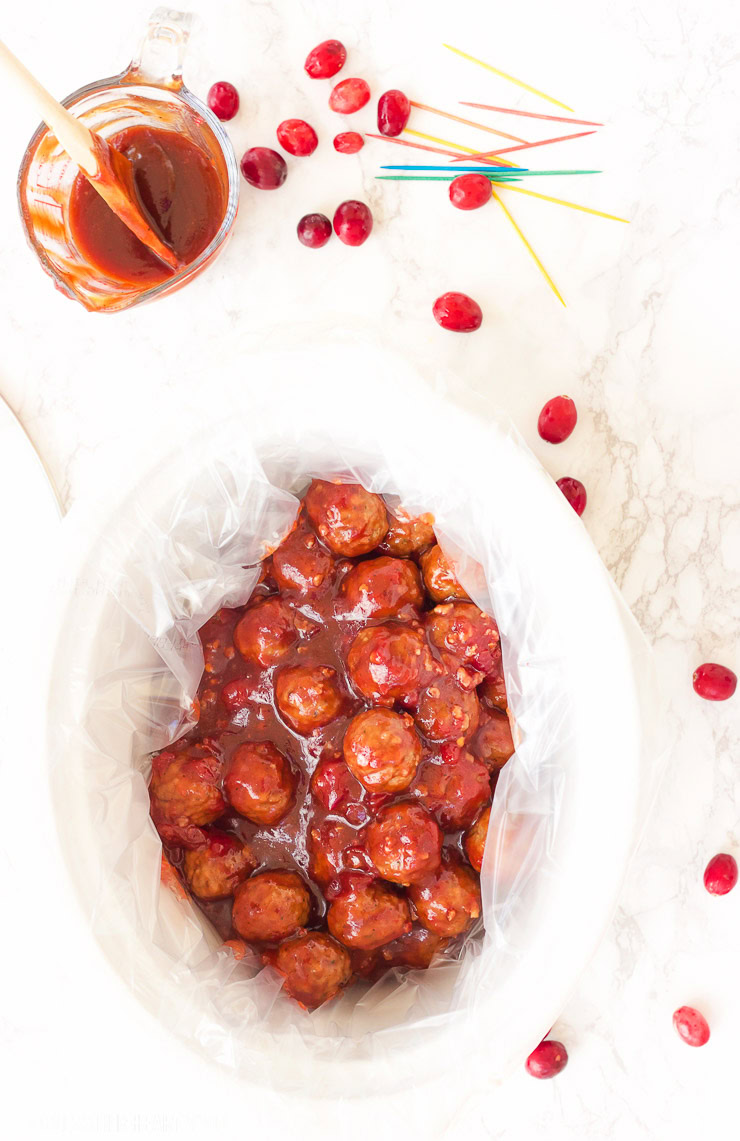 These spicy cranberry bacon bbq meatballs are the ultimate in sticky finger foods just in time for the holidays! A quick homemade cranberry sauce is melted and smothered into barbecue sauce and hot spices for the perfect sweet and spicy no-fuss pop-able party bites!