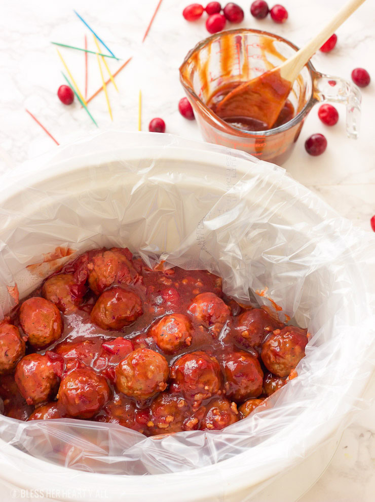 These spicy cranberry bacon bbq meatballs are the ultimate in sticky finger foods just in time for the holidays! A quick homemade cranberry sauce is melted and smothered into barbecue sauce and hot spices for the perfect sweet and spicy no-fuss pop-able party bites!